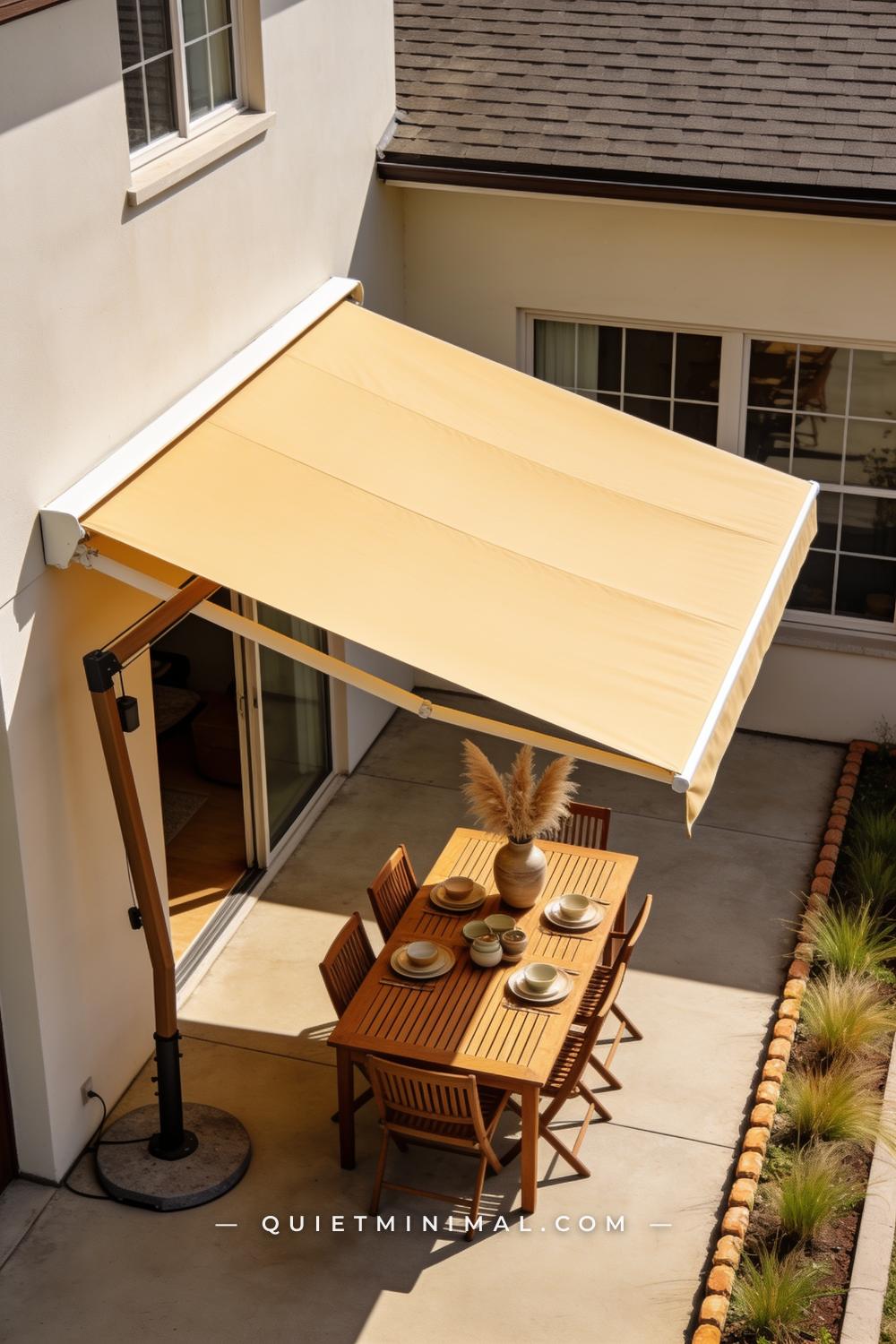 A vertical photograph captures a wide patio scene anchored by a large cantilever umbrella in a warm ivory canvas stretch