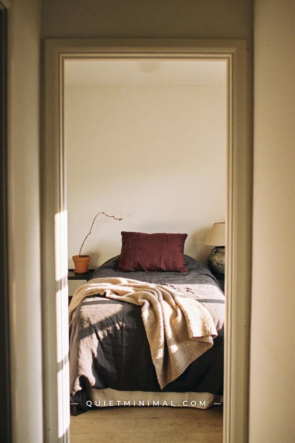 A wide establishing shot from the far end of a bedroom