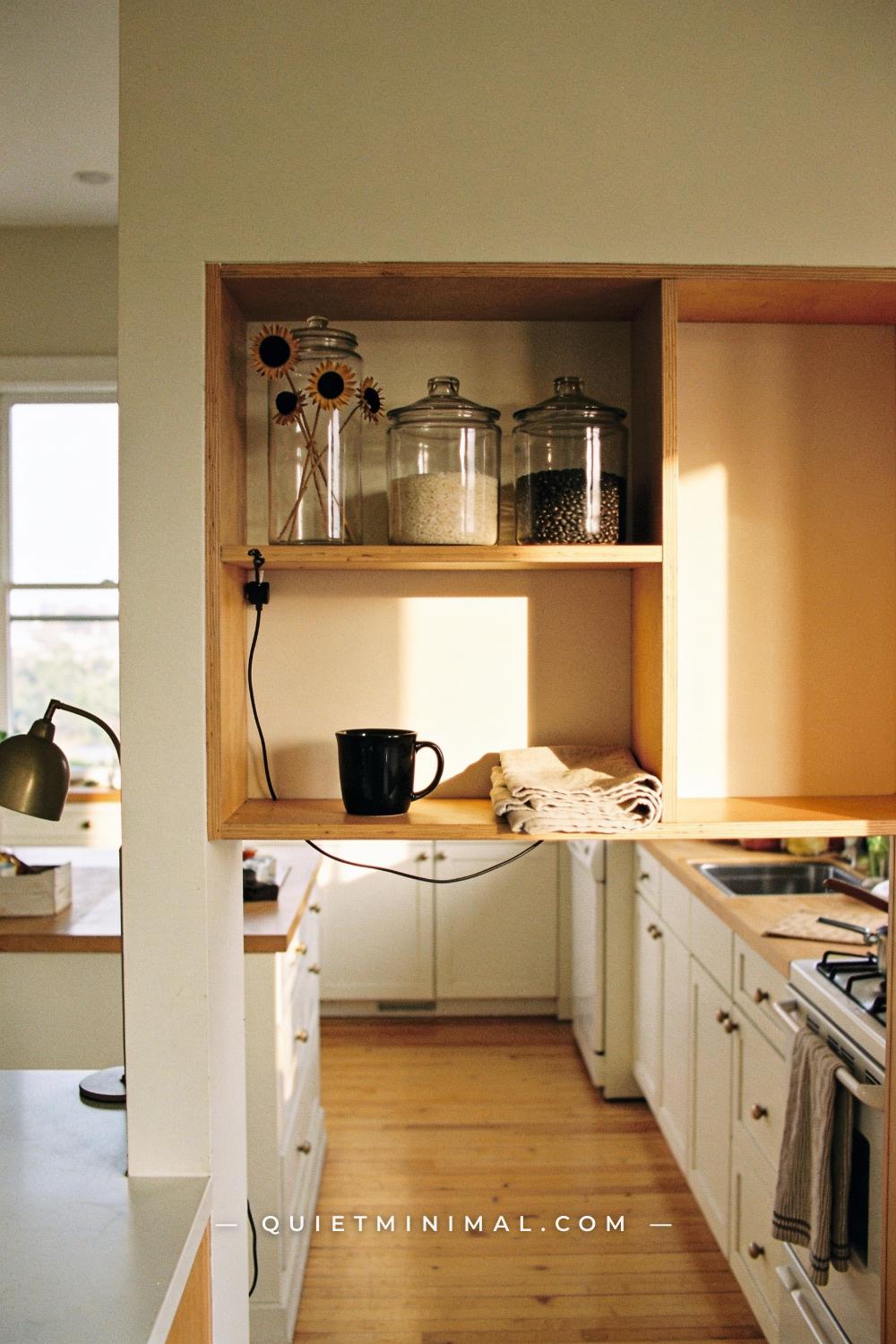A wide establishing shot from across a kitchen or open shelving area