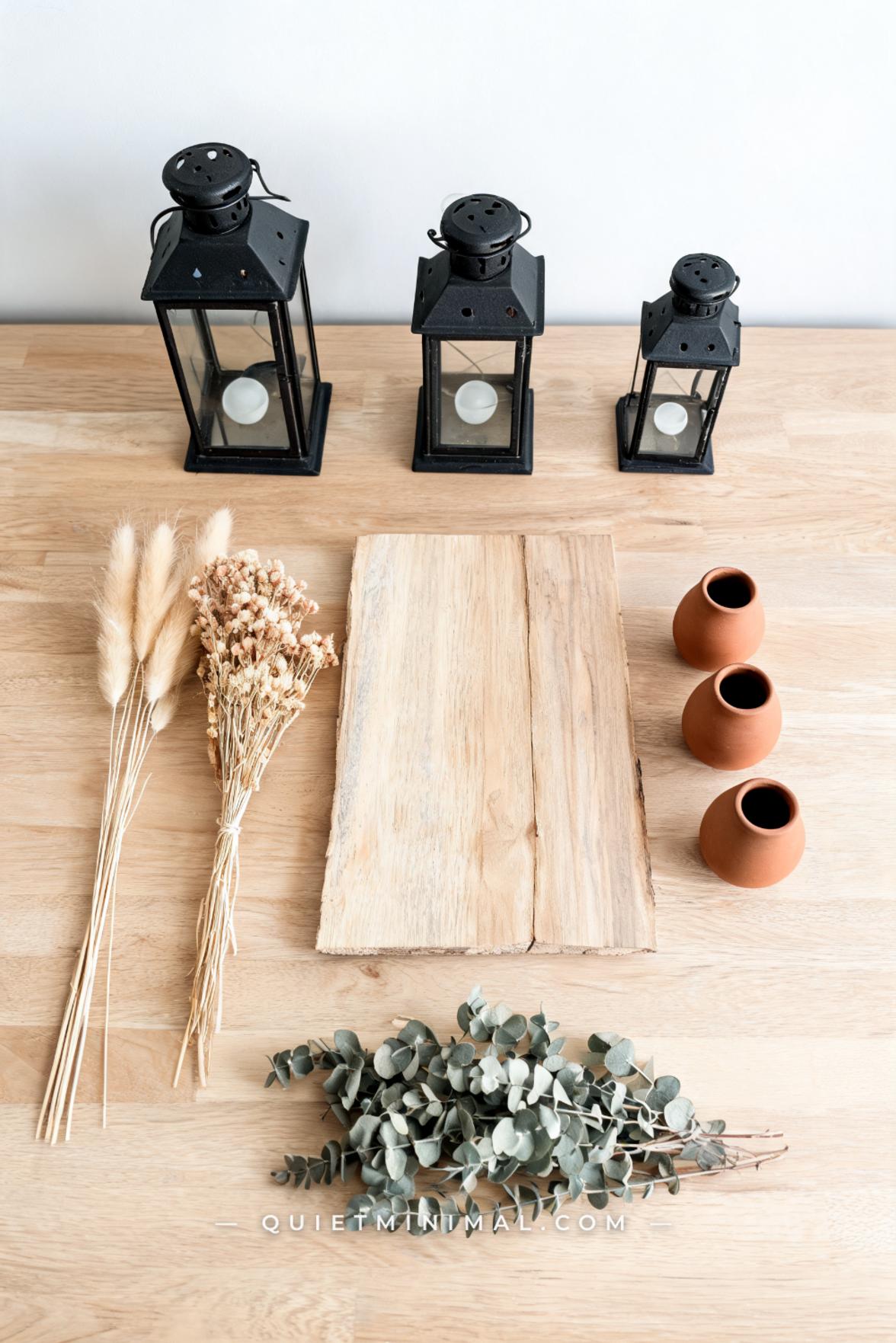 A vertical wide-angle photograph captures a full rustic wedding table centerpiece laid out in a flat arrangement on a pa