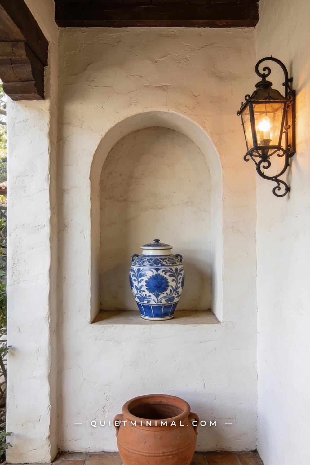 A medium-wide photograph of a Spanish Revival patio stucco wall featuring a recessed arched wall niche at eye level