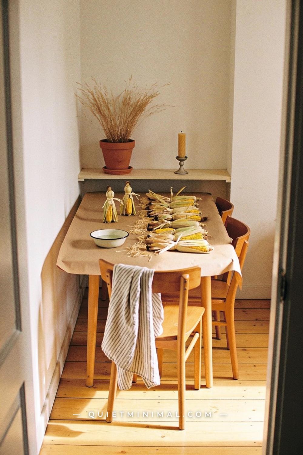 A wide establishing shot from a doorway view of a bright small dining nook
