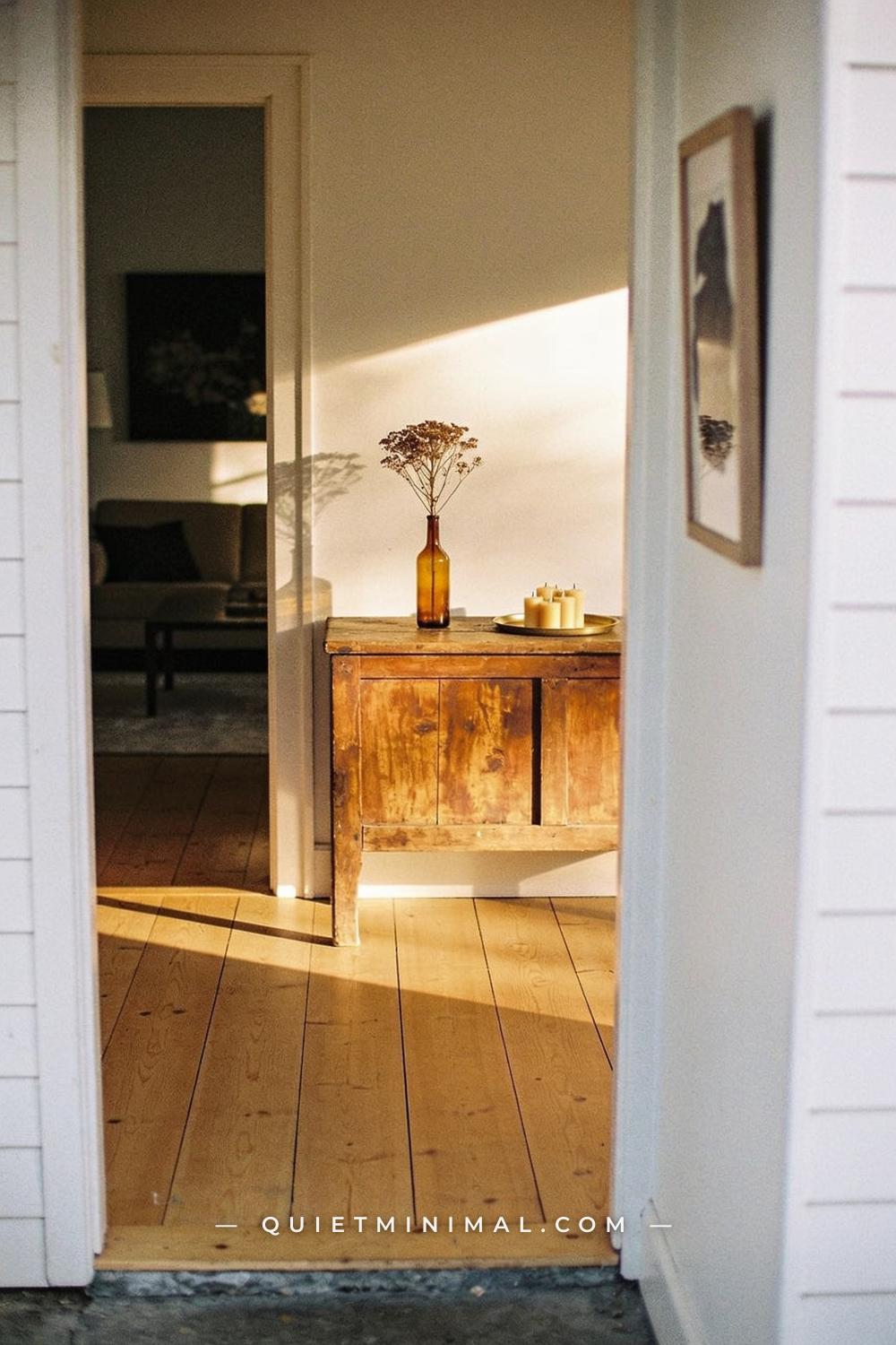A wide establishing shot from the far end of a hallway looking into a living room