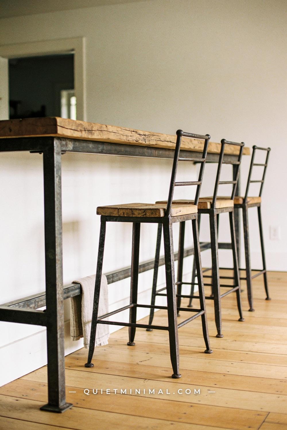 A wide establishing shot looking along the seating side of a wabi-sabi kitchen island