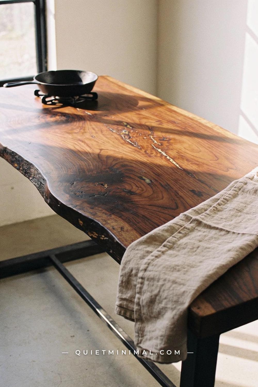 A seated eye-level establishing shot of a wabi-sabi kitchen island showing the full top surface from a slightly low angl